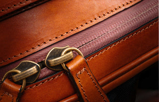 Double-pull brass zipper on leather.
